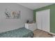 Well lit bedroom features pale-green accent wall and light colored wood flooring at 2914 Clarabelle Ct, Kissimmee, FL 34743
