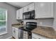 Well lit kitchen features granite countertops and white cabinets offering great space and style at 2914 Clarabelle Ct, Kissimmee, FL 34743
