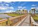 Beautiful community view with colorful homes, lush greenery, and a charming bridge over a waterway at 2978 Latitude Ln, Kissimmee, FL 34747