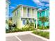 Charming two-story coastal cottage with colorful facade, white balcony, manicured landscaping, and sidewalk access at 2978 Latitude Ln, Kissimmee, FL 34747