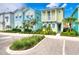 Colorful two-story coastal cottages with pastel exteriors, balconies, blue shutters, lush landscaping, and parking at 2978 Latitude Ln, Kissimmee, FL 34747