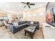 Open-concept living room and kitchen featuring a plush gray sectional sofa, wood-look tile flooring, and stainless appliances at 2978 Latitude Ln, Kissimmee, FL 34747