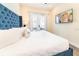Serene bedroom with a plush blue headboard, white bedding, TV, and a private patio access at 2978 Latitude Ln, Kissimmee, FL 34747