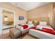 Cozy bedroom with two beds, a mounted TV, and a glimpse into an attached bathroom at 3228 Brasilia Ave, Kissimmee, FL 34747