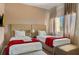 Bright bedroom featuring two twin beds, soft neutral colors, and comfortable furniture at 3228 Brasilia Ave, Kissimmee, FL 34747