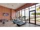 Modern gym with workout equipment, floor to ceiling windows, and brick wall, promoting a healthy lifestyle at 3228 Brasilia Ave, Kissimmee, FL 34747