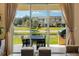 View from the living area to the patio with dining table and chairs, a grill, and a beautiful water view at 3228 Brasilia Ave, Kissimmee, FL 34747