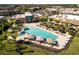 Aerial view of a luxurious community pool featuring multiple buildings, chairs, and palm trees at 3228 Brasilia Ave, Kissimmee, FL 34747