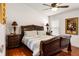 Comfortable bedroom with rich hardwood flooring and large decorative artwork at 3536 Moss Pointe Pl, Lake Mary, FL 32746