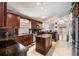 Elegant kitchen featuring dark wood cabinets, granite countertops, stainless steel appliances, and center island at 3536 Moss Pointe Pl, Lake Mary, FL 32746