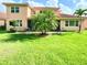 Expansive backyard with lush green grass, tropical palm trees, and a patio area at 4120 Juliana Lake Dr, Auburndale, FL 33823
