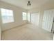 Bright bedroom featuring two windows, neutral carpet, and a closet with sliding doors at 4120 Juliana Lake Dr, Auburndale, FL 33823