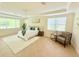 Sun-drenched bedroom with large windows, white rug, chair, and neutral furniture at 4120 Juliana Lake Dr, Auburndale, FL 33823
