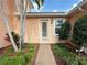 Charming front door with brick walkway surrounded by lush landscaping and well-maintained bushes at 4120 Juliana Lake Dr, Auburndale, FL 33823