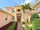 Stunning two-story home with lush landscaping, mature palms, and a welcoming front porch at 4120 Juliana Lake Dr, Auburndale, FL 33823