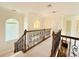Well-lit hallway with decorative wrought iron railing and lots of natural light from arched windows at 4120 Juliana Lake Dr, Auburndale, FL 33823