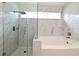 Bathroom showcasing a walk-in shower with frameless glass and marble-look wall tiles at 4404 Gwyndale Ct, Orlando, FL 32837