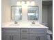 Bathroom featuring double sink vanity with gray cabinets and rectangular framed mirrors at 4404 Gwyndale Ct, Orlando, FL 32837