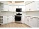 Bright kitchen features white cabinets, modern appliances, and countertops, and stylish wood-look flooring at 4404 Gwyndale Ct, Orlando, FL 32837