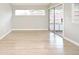 Bright living room featuring light, wide plank flooring and a large sliding door to a sunroom at 4404 Gwyndale Ct, Orlando, FL 32837