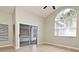 Primary bedroom with wide plank flooring, sliding door to a sunroom, and a large arched window at 4404 Gwyndale Ct, Orlando, FL 32837