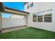 View of the backyard with artificial turf and a brick patio, as seen from the side of the house at 5089 Caspian St, St Cloud, FL 34771
