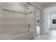 Bright bathroom featuring tub and shower combo with tiled walls and a glimpse of the bedroom at 5089 Caspian St, St Cloud, FL 34771
