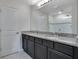 Bright bathroom features a double sink vanity with a granite countertop and a walk-in shower at 5089 Caspian St, St Cloud, FL 34771