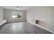 This bedroom features wood flooring, two windows with shades, and a floating cabinet at 5089 Caspian St, St Cloud, FL 34771