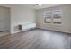 This bright bedroom features wood flooring, two windows, a ceiling fan, and a modern floating cabinet at 5089 Caspian St, St Cloud, FL 34771