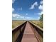 Scenic boardwalk stretching through marshland under a vibrant blue sky with scattered clouds at 5089 Caspian St, St Cloud, FL 34771