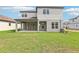 Backyard view showcasing a covered patio, a well-maintained lawn, and the home's exterior at 5260 Citrus Leaf Blvd, Winter Garden, FL 34787