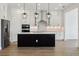 Gourmet kitchen with a black island, stainless appliances, and pendant lighting at 5260 Citrus Leaf Blvd, Winter Garden, FL 34787