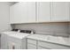 Convenient laundry room featuring modern washer and dryer, sink, and cabinet space at 5290 Citrus Leaf Blvd, Winter Garden, FL 34787