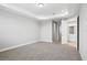 Spacious bedroom with tray ceiling, neutral carpet, and entrance to the bathroom at 5307 Citrus Leaf Blvd, Winter Garden, FL 34787