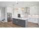 Modern kitchen boasts stainless steel appliances, subway tile backsplash, gray island and white cabinets at 5307 Citrus Leaf Blvd, Winter Garden, FL 34787