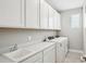 A well-lit laundry room has appliances, storage, and a sink for ultimate convenience at 5307 Citrus Leaf Blvd, Winter Garden, FL 34787