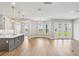 Bright living room features wood floors, white walls, and a kitchen island overlooking an expansive area and french doors at 5307 Citrus Leaf Blvd, Winter Garden, FL 34787