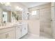 Bright bathroom with double vanity, white cabinets, and a glass-enclosed shower with a built-in seat at 545 Moon Shell Cir, New Smyrna Beach, FL 32168