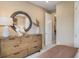 Cozy bedroom featuring a wooden dresser with a round mirror, neutral walls, and soft lighting at 545 Moon Shell Cir, New Smyrna Beach, FL 32168