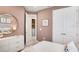 Charming bedroom featuring pink walls, a gold mirror, and a white dresser, creating a cozy and inviting atmosphere at 545 Moon Shell Cir, New Smyrna Beach, FL 32168