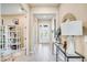 Hallway with decorative lamps, mirror, console table and view of the home's front entrance at 545 Moon Shell Cir, New Smyrna Beach, FL 32168