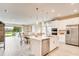 Bright, modern kitchen with a large island, stainless steel appliances, and pendant lighting that opens to the living room at 545 Moon Shell Cir, New Smyrna Beach, FL 32168