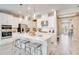 Modern white kitchen featuring stainless steel appliances, large island with seating, and pendant lighting at 545 Moon Shell Cir, New Smyrna Beach, FL 32168