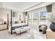 Inviting primary bedroom with decorative pillows, large windows, and a bench at 545 Moon Shell Cir, New Smyrna Beach, FL 32168