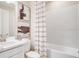 Bright bathroom featuring a shower-tub combination with striped shower curtain and modern wall art at 553 Moon Shell Cir, New Smyrna Beach, FL 32168