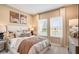 Cozy bedroom with neutral decor, plush bedding, and abundant natural light from two windows at 553 Moon Shell Cir, New Smyrna Beach, FL 32168