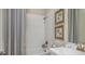 Clean bathroom features a shower-tub combo, white tiled walls, and neutral decor at 556 Moon Shell Cir, New Smyrna Beach, FL 32168