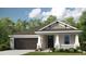 Charming single-story home with a gray and white exterior, manicured lawn, and attached two-car garage at 556 Moon Shell Cir, New Smyrna Beach, FL 32168