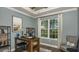 Well-lit home office with stylish decor, hardwood floors, and a large window overlooking the lawn at 556 Moon Shell Cir, New Smyrna Beach, FL 32168